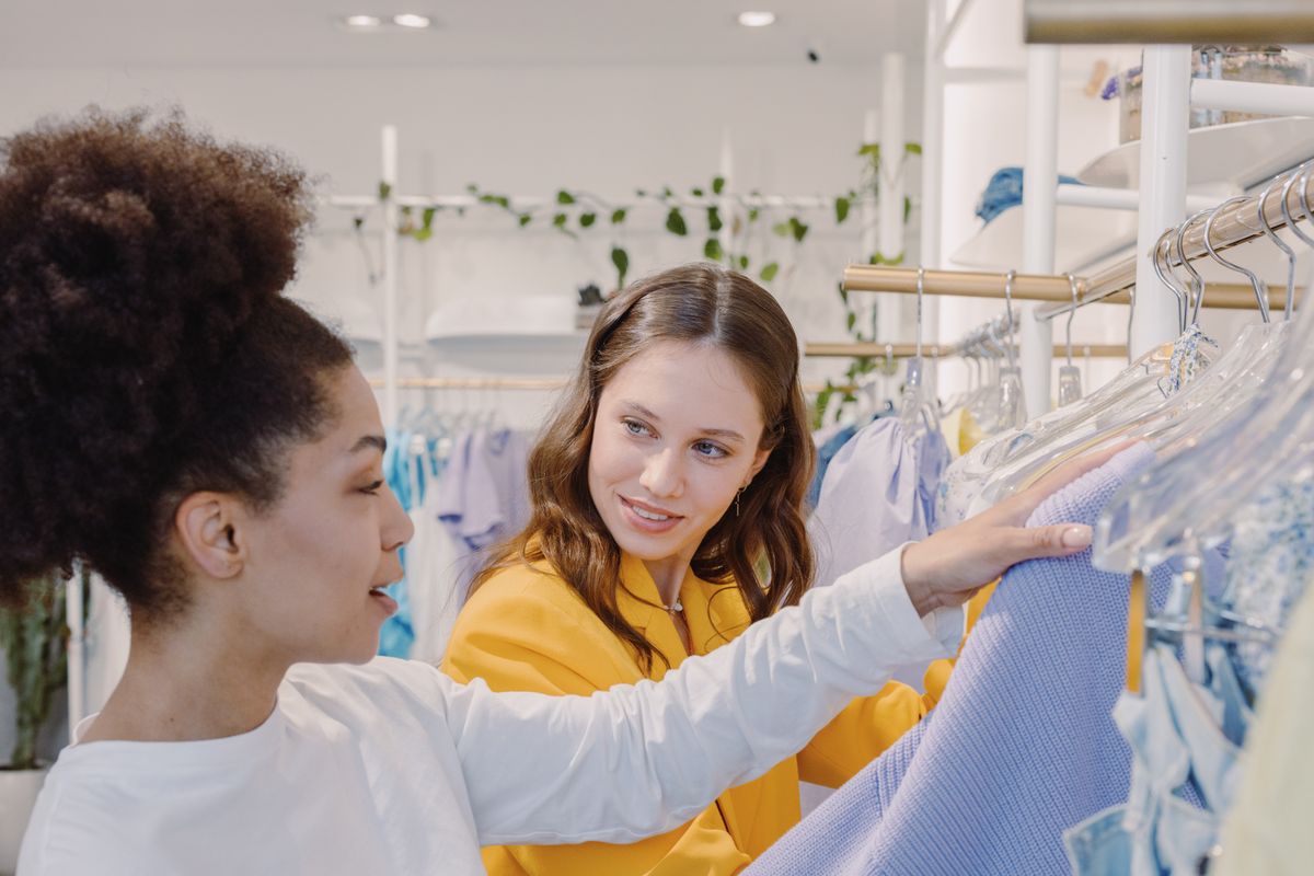 Women discussing outfit choices at a clothing rack